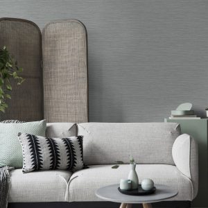 Room shot of the Deeply Textured Grey Grasscloth Wallpaper installed in a living room with couch and coffee table in foreground