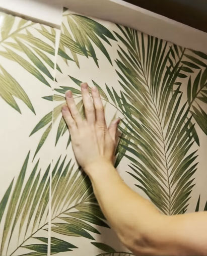 Photo demonstrating how to join wallpaper with an offset pattern match. The wallpaper shown is palm leaves and the pattern is small.