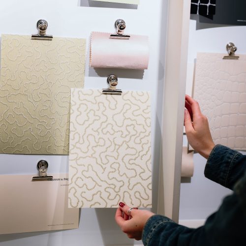 Holding a wallpaper sample from an interiors mood board