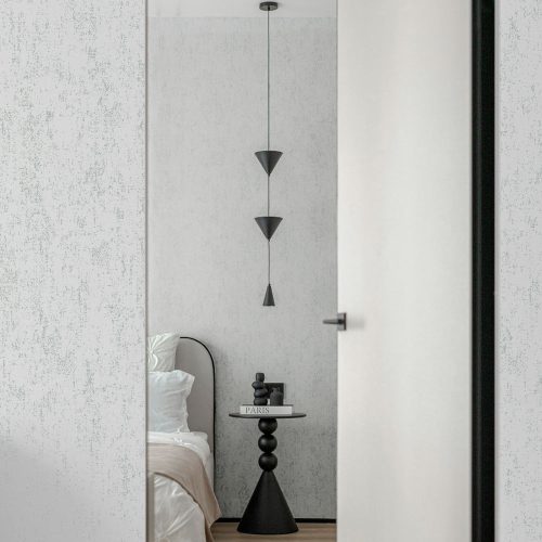 Concrete-effect-wallpaper-grey-metallic-silver-details Hotel room door opening onto bedroom with Metallic Silver Grey Mineral Plaster Wallpaper on the walls. Also shows a bed, table and pendant light fitting.