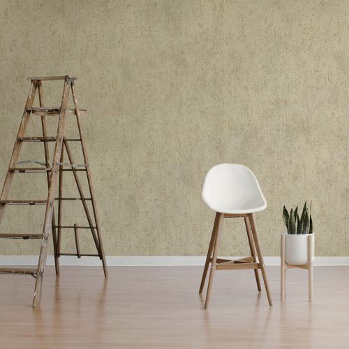 concrete-effect-wallpaper-metallic-gold-beige Room shot of the Concrete Effect Wallpaper in Metallic Gold and Beige installed on wall. Ladder, chair and pot plant are in the foreground.