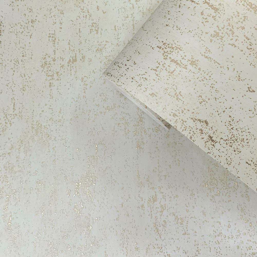 Close up of a roll of Mineral Plaster Wallpaper with metallic gold accents on a cream background