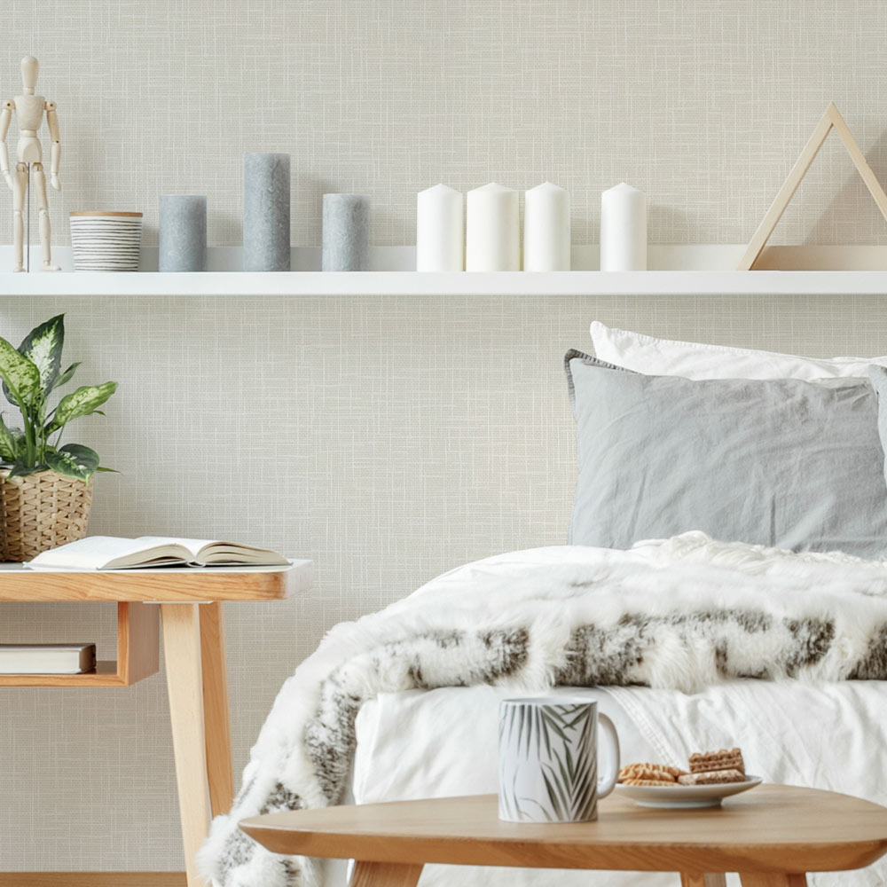 Bedroom with the Woven Hessian Wallpaper Beige installed on the wall. The wall also features a shelf with natural earthenware, side table and a bed with linen throw.