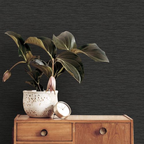 Entrance hall with the Deeply Textured Grasscloth Wallpaper Black installed on the wall. Also features a retro drawer unit with a plant and small desk clock in foreground