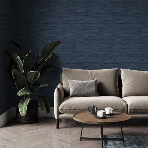 Lounge with the Navy Textured Plaster Wallpaper installed on the wall. Foreground is a couch, large plant, scandanavian coffee table with cups on wooden floor