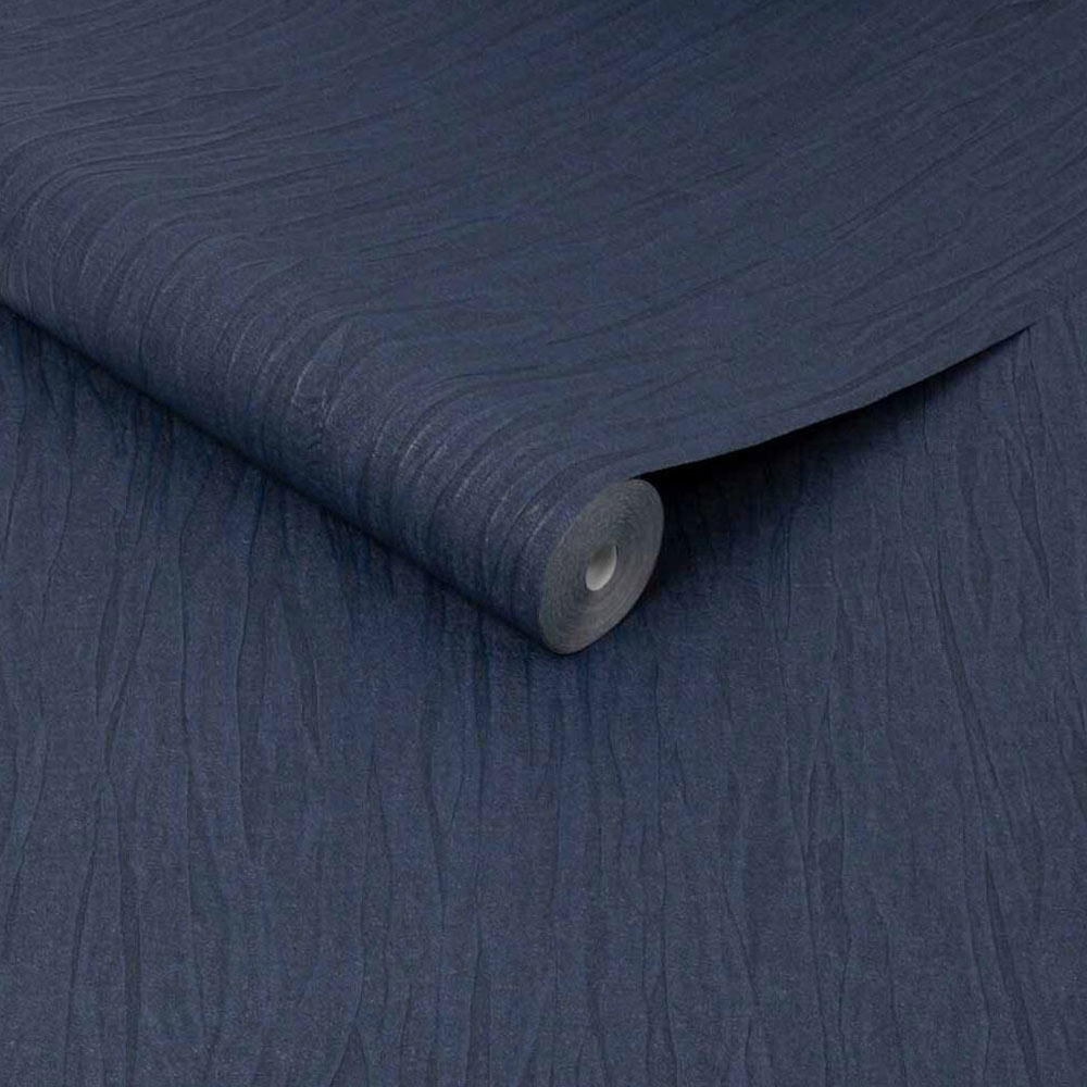 Roll of folded silk look wallpaper in sapphire blue showing light metallic flecks, slightly unrolled