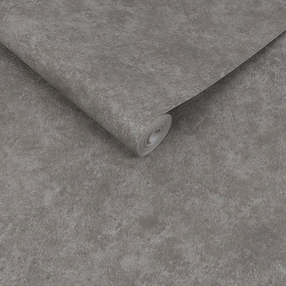Roll of grey faux plaster wallpaper showing metallic details and plaster texture