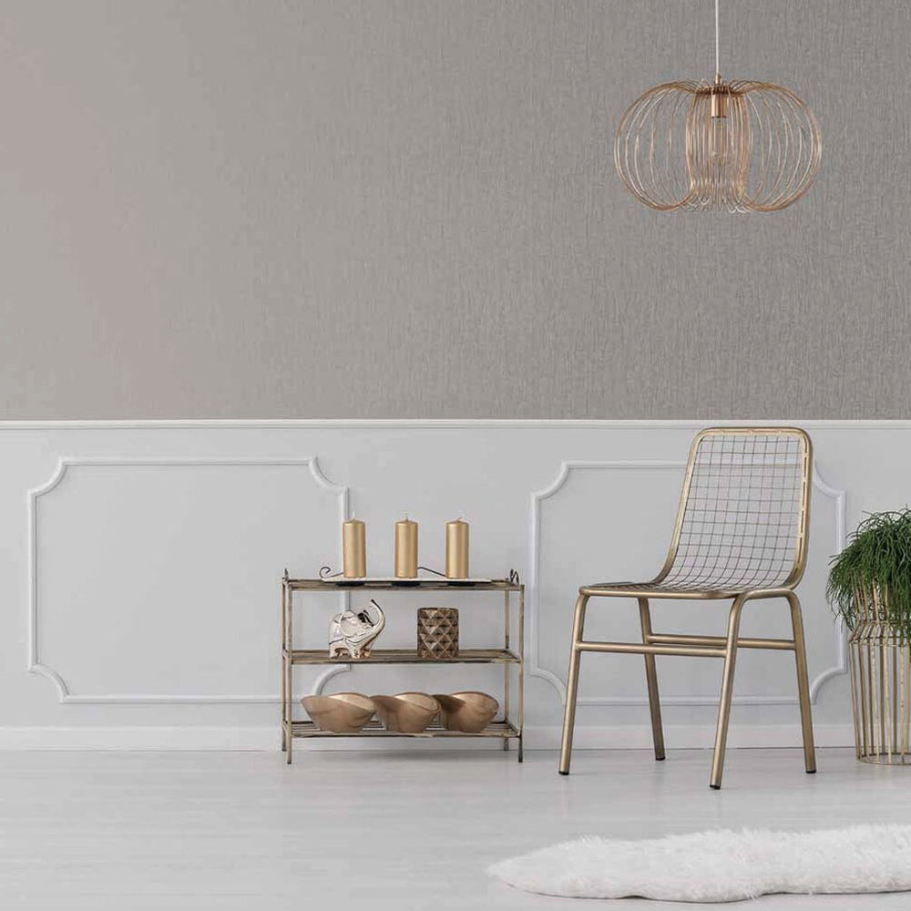 Styled room with the Metallic Draped Silk Wallpaper Quartz installed on half of the wall. Also features gold metal chair, copper pendant light, dispaly table with candles and accessories plus plant on stand