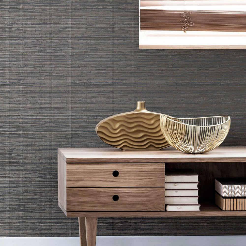 Lounge with metallic grasscloth wallpaper smokey quartz installed on the wall. Also features an earthy abstract painting plus low wooden sideboard with vase, gold metal bowl and books