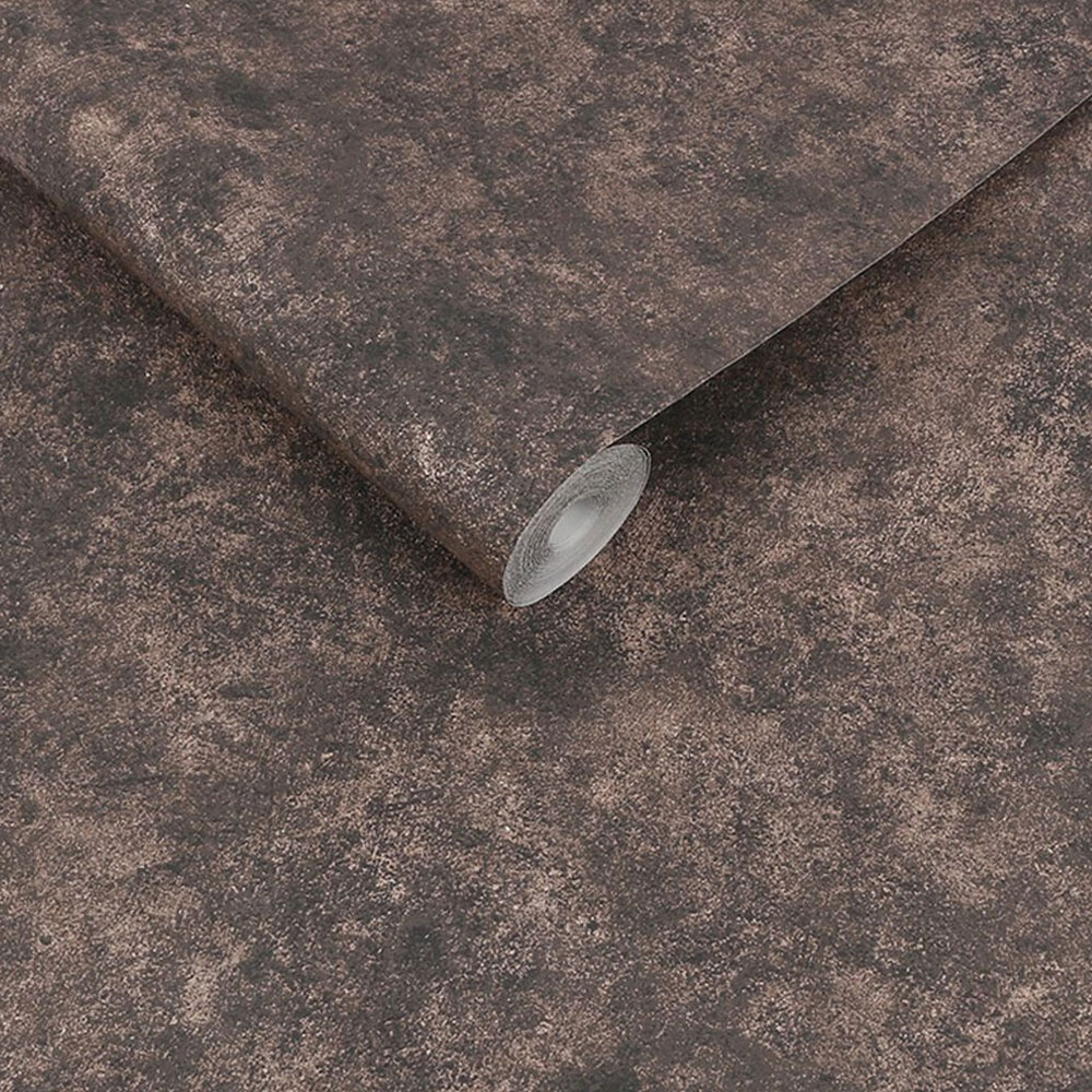 Roll of metallic plaster look wallpaper with textured charcoal tones and rose gold detailing