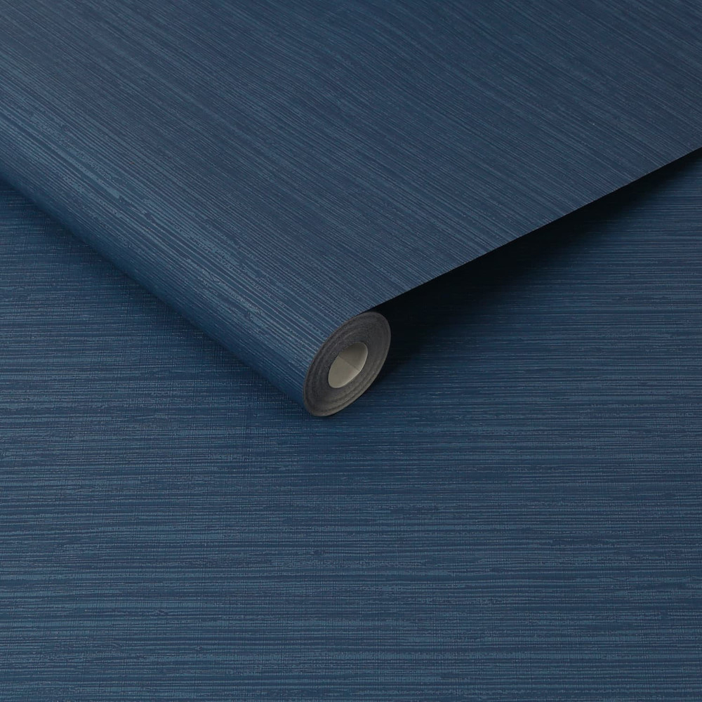 Roll of Navy Blue Deeply Textured Plaster Wallpaper slightly unrolled on a base of the same grass cloth wallpaper
