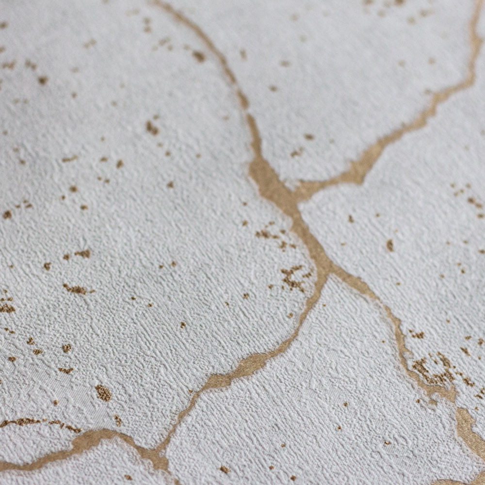 Ultra close-up of the textured detail of the concrete plaster look with debossed metallic gold veining