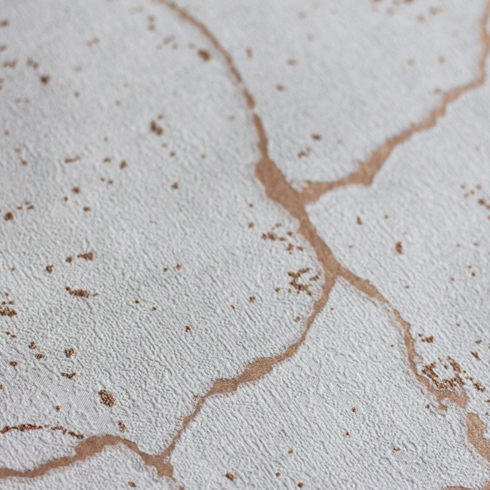 Ultra close-up of the textured detail of the concrete plaster look with debossed metallic rose gold veining