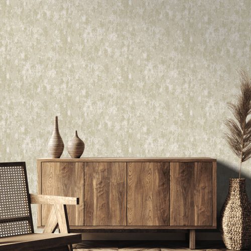 Styled photo of the installed weathered concrete wallpaper cream gold on the wall. Foreground features a wooden sideboard, modern wood chair, earthen vases and a large Pampas grass reed.