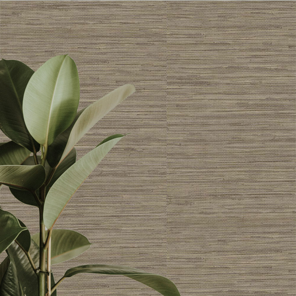 Close up of the installed realistic looking grasscloth wallpaper, also shows leafy plant in the foreground