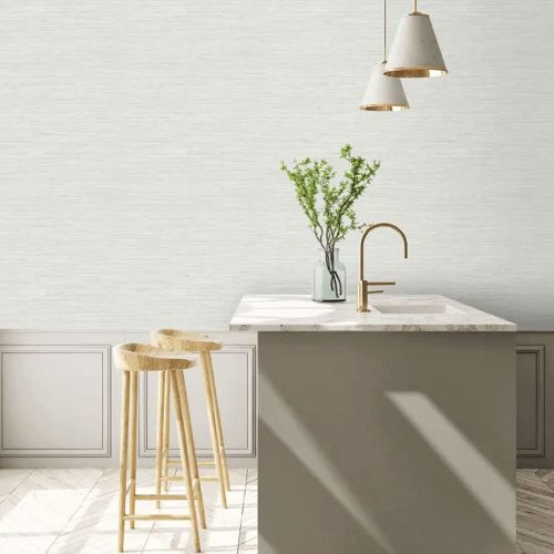 Kitchen with the woven grasscloth wallpaper silver silk installed on the wall. Foreground shows kitchen island with wooden bar stools, flowers in vase and 2 pendant lights